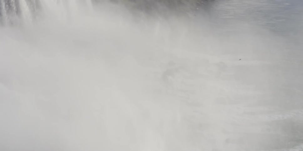 A vast waterfall covering a valley in mist