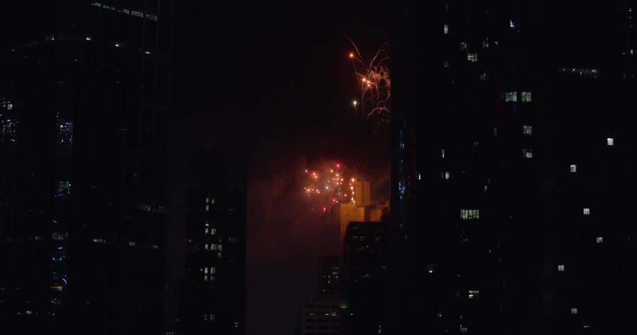 Fireworks shot off into the sky in a citys downtown area