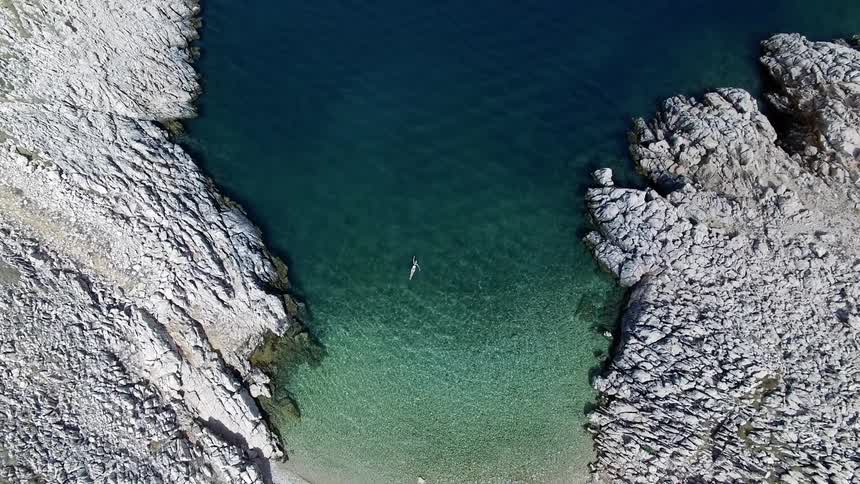 Aerial footage of a woman floating in the Mediterranean Sea
