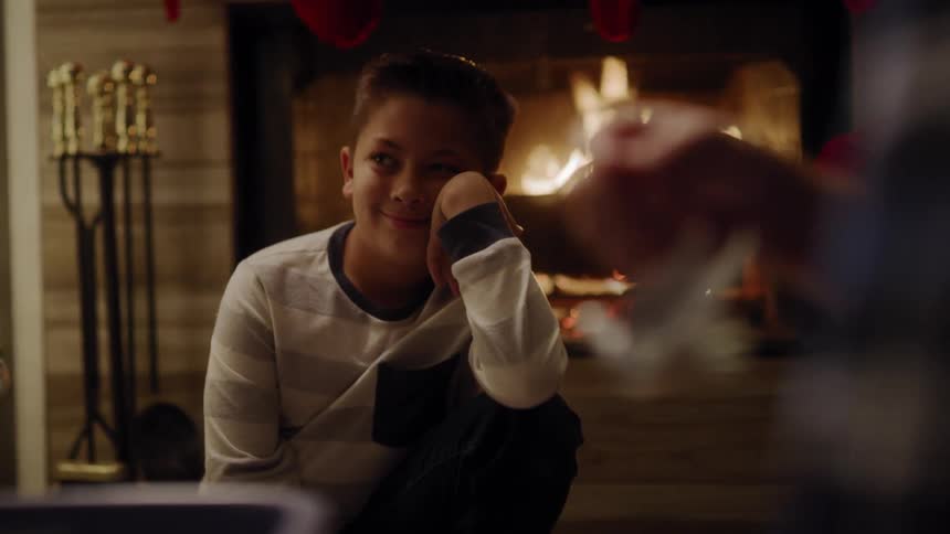 A boy sits near the chimney with his family