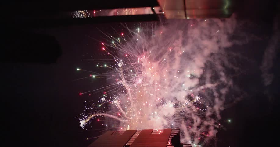 A fireworks display at night viewed from inside of a vehicle