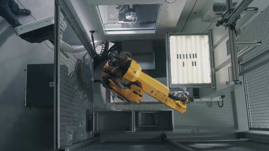 A man controls a large robotic arm