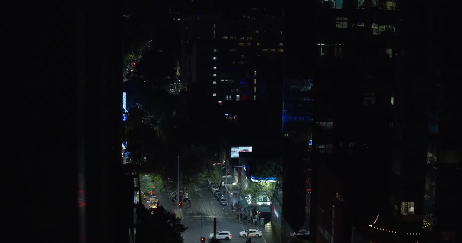Fireworks explode over brightly lit city street