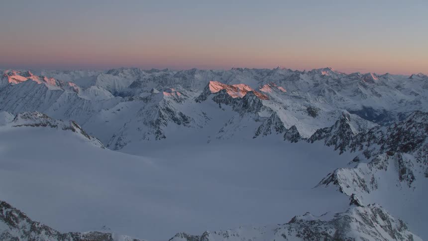 Snow covered rocky mountain ridges at sunset