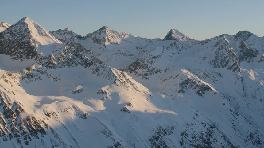 A snow covered mountain ridge during the day
