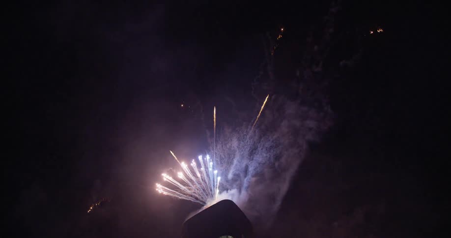 Fireworks exploding from the top of a building
