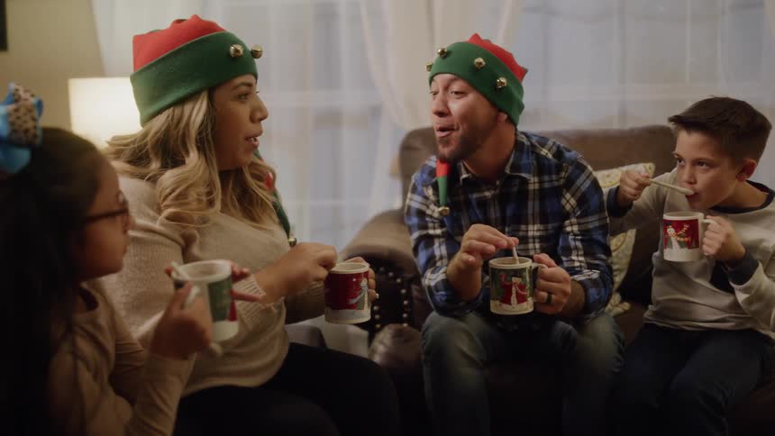 A family sitting in the living room drinking hot chocolate