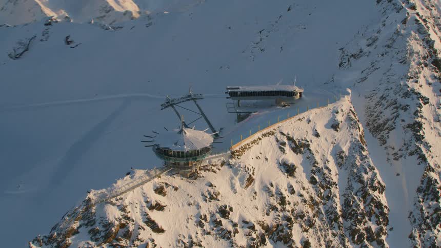 Buildings sit on the peak of a snow covered mountain
