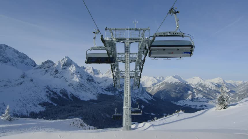 Vacant chair lifts moving across the lift on a ski resort