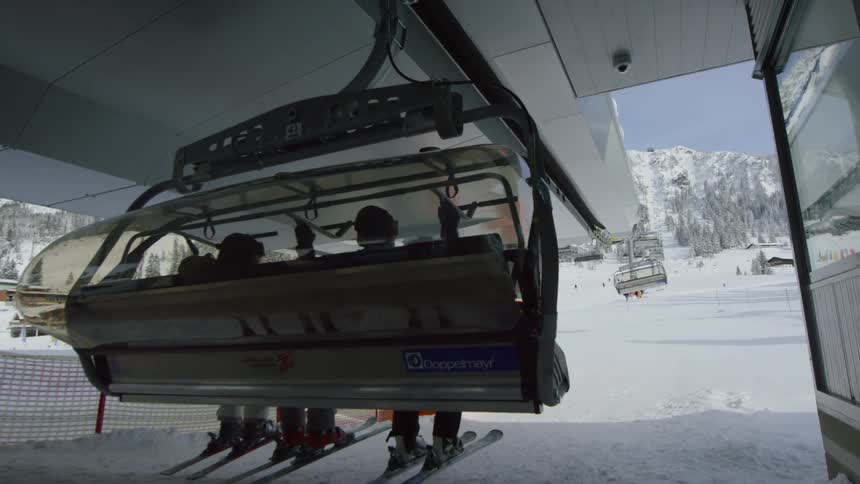 People are wearing skiing equipment and on a ski lift