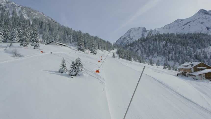 Several people ski across a flat snow terrain