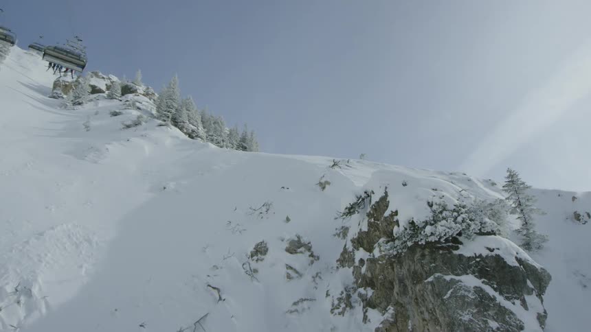 Ski lifts are operated in snowy mountains on a sunny day