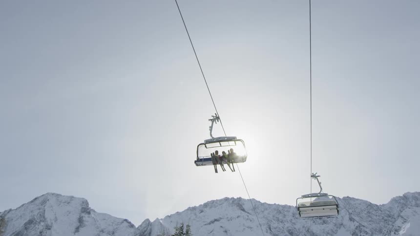 Skiers are carried above the snow on a ski lift