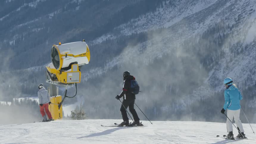 Several people are skiing down a slope on a mountain