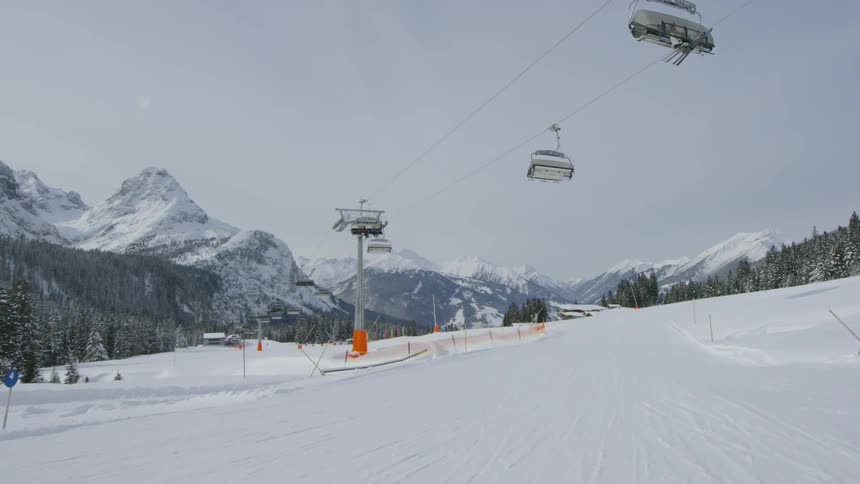 Ski lift passes over ski slope between mountains
