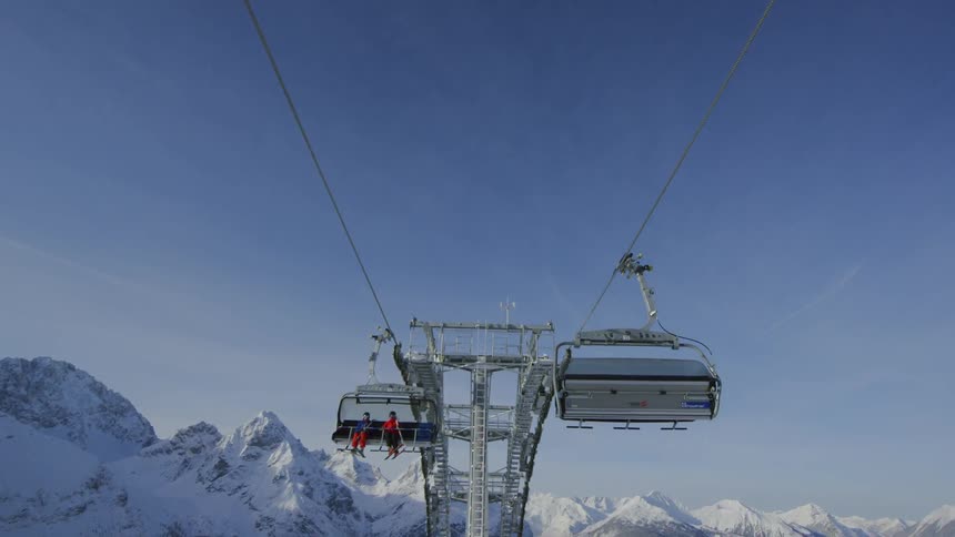 People ride the ski lift with the skis