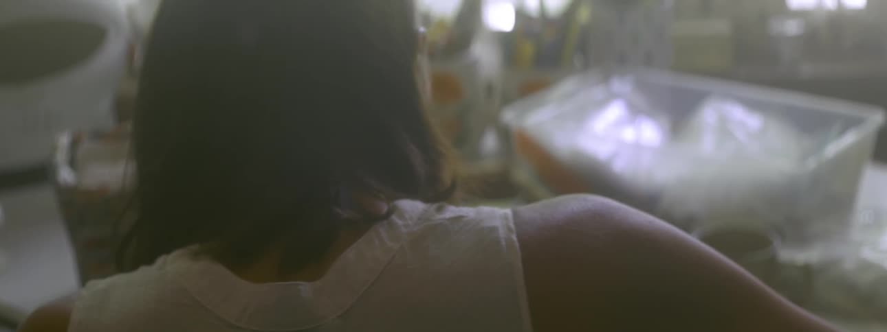 A person in a white shirt hunched over a desk