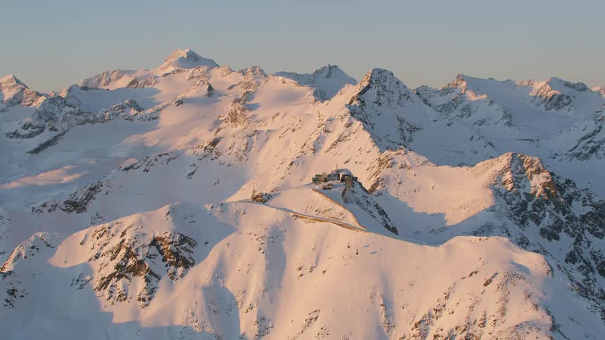 Aerial view of snow covered mountain ridge at sunset