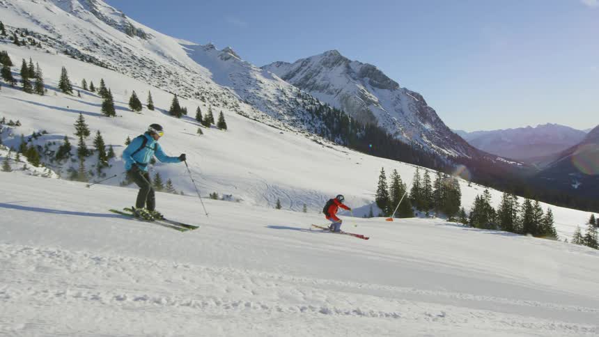 People doing a downhill with a snow board at the snow resort