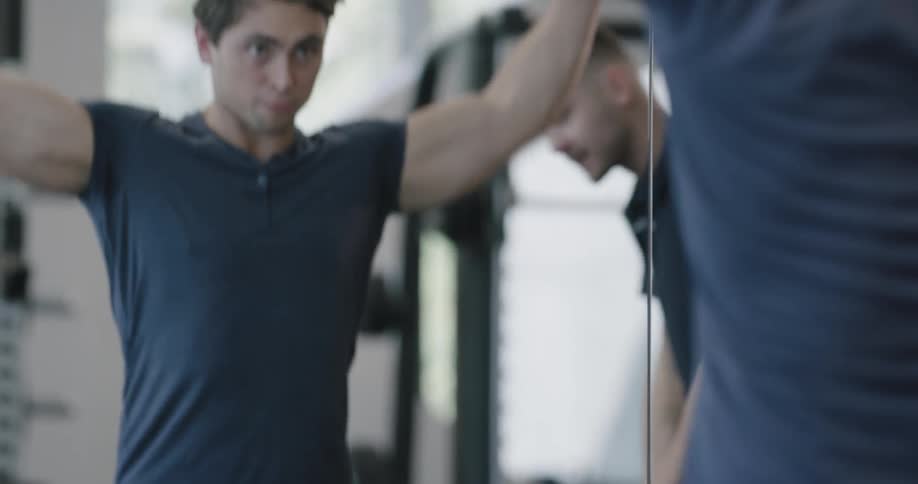 Man lifts weights under trainer supervision