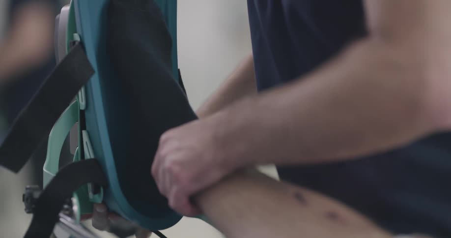 A man puts another mans leg in a brace
