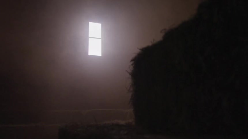 A bale of hay in a room with a single window