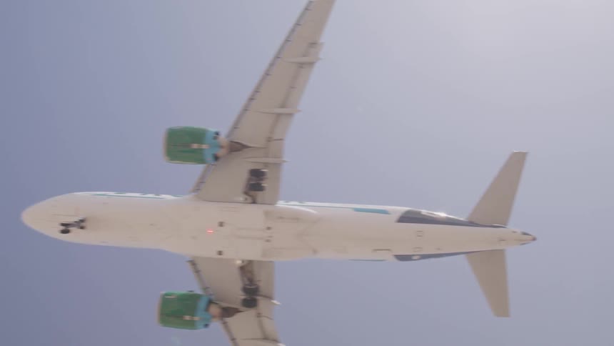 Close up of commercial passenger airplane flying overhead