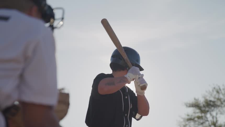 A portrait of a man hitting a ball with a baseball bat