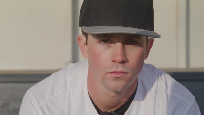 A man in a baseball uniform is sitting