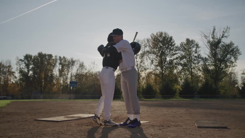 Men hugging each other after playing baseball