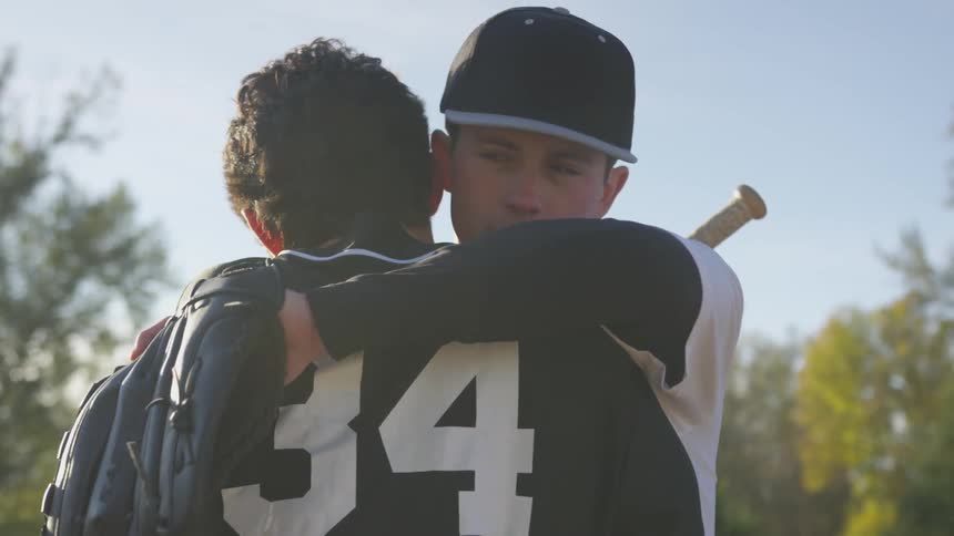 Two men hug at a baseball game