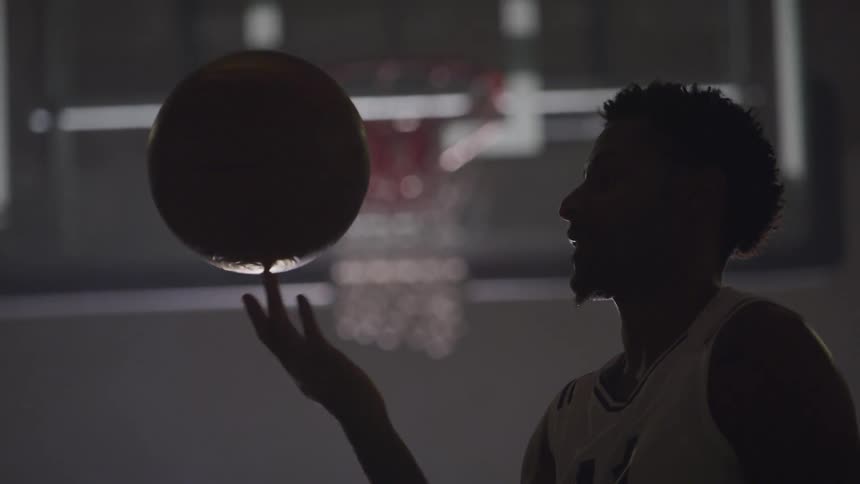 A man is playing basketball indoors