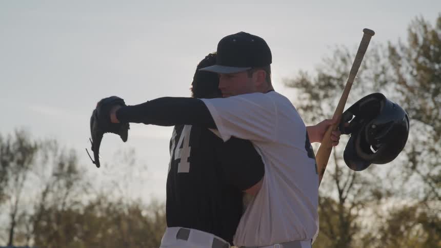 Two men hug at a baseball game
