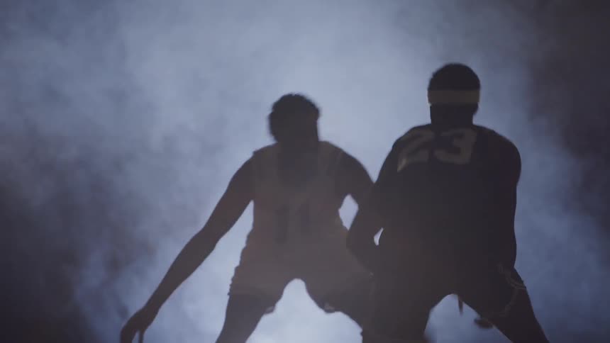 Men playing basketball under the light