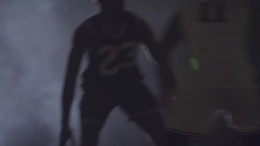 Two men play basketball in a smoke filled environment