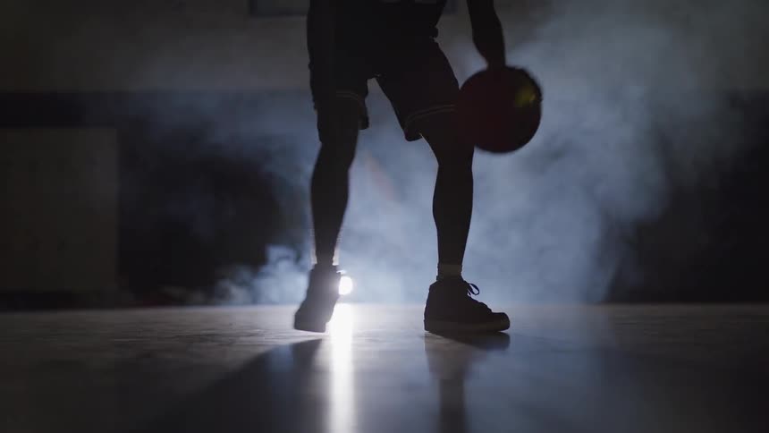 A silhouette of a man playing basket ball