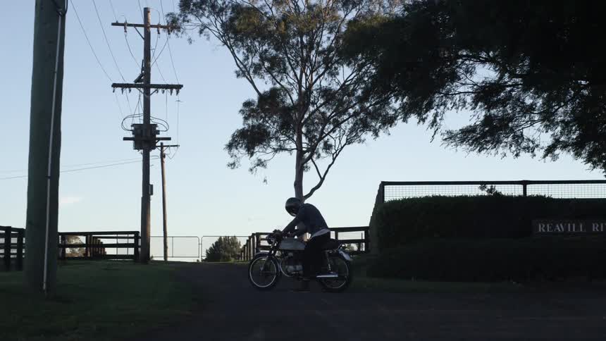 A person is sitting on a bike in a lot at sunrise