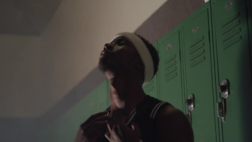 An athlete moves around in a locker room