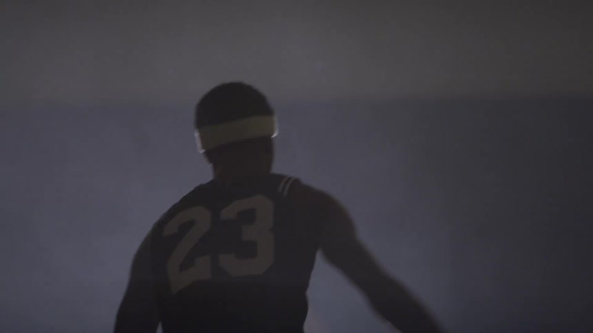 A black man playing basketball in the indoor field