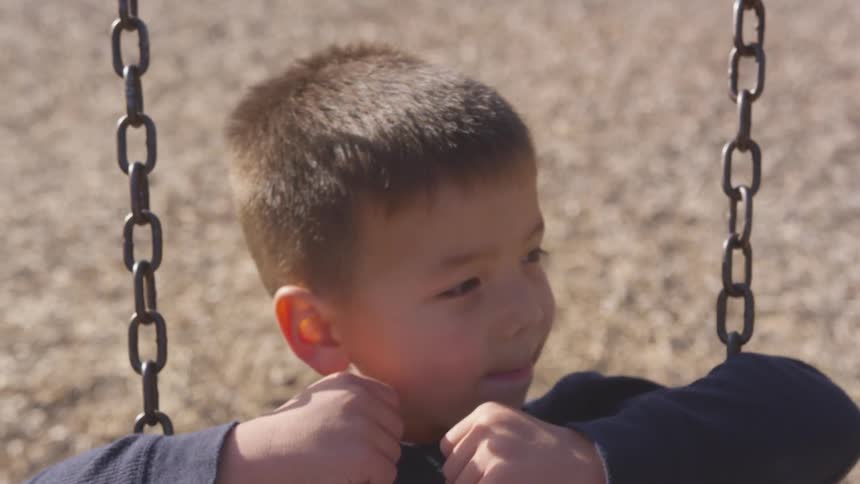 Boy swings on swing in the playground