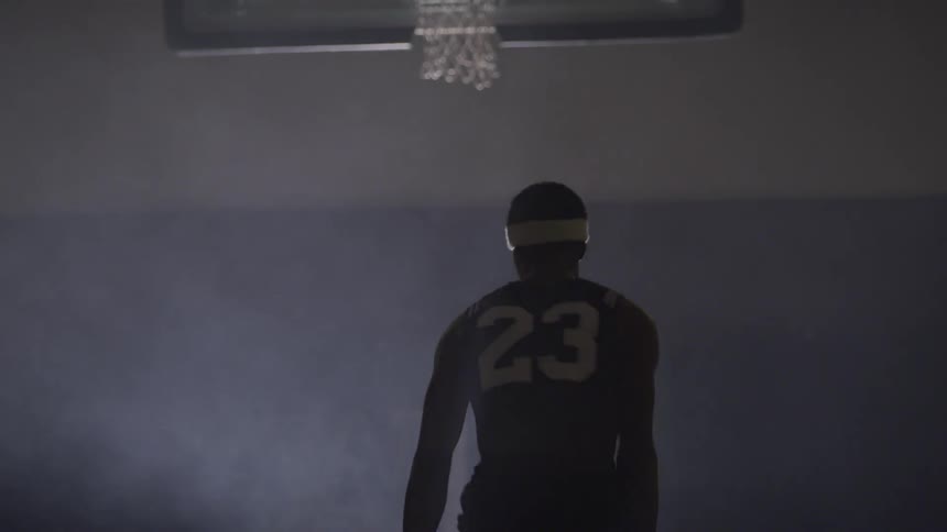 A black man dribbling a basketball