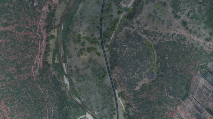 A road wanders next to a river in rough terrain