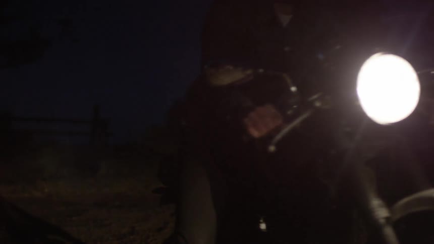 A person riding a bike with a headlight at night