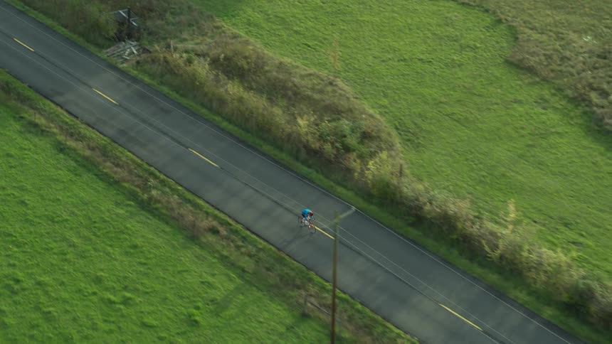 An aerial footage of a man cycling in the road