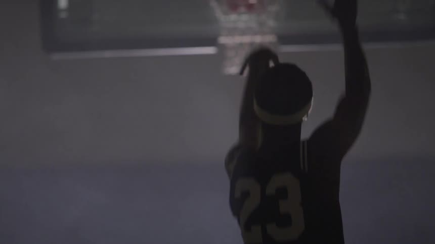 A black man doing a basketball shot