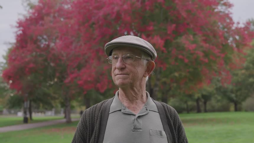 An elderly man is outdoors at a park
