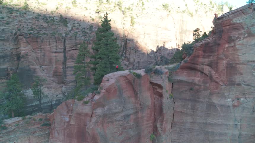 A person stands on a sandstone ridge