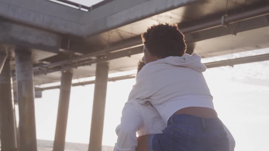 A husband is holding his wife outdoors