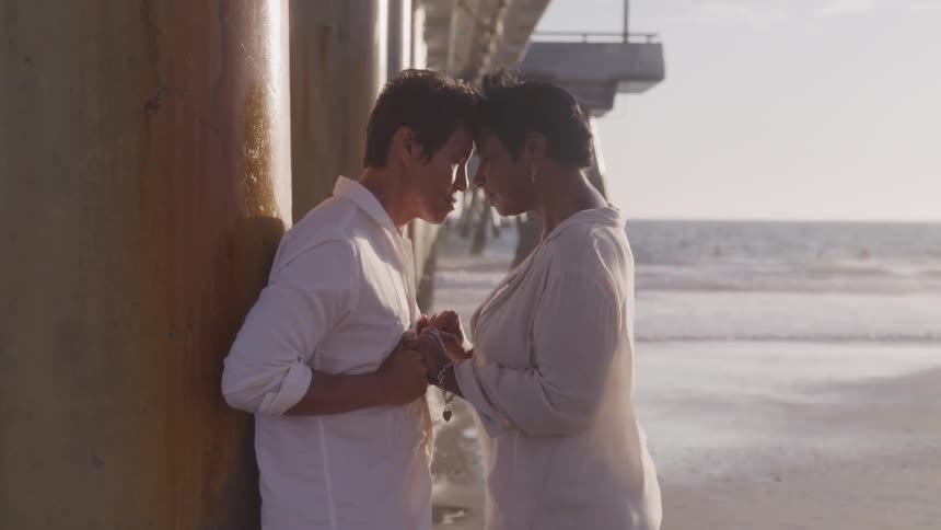 Man and woman hold hands on beach