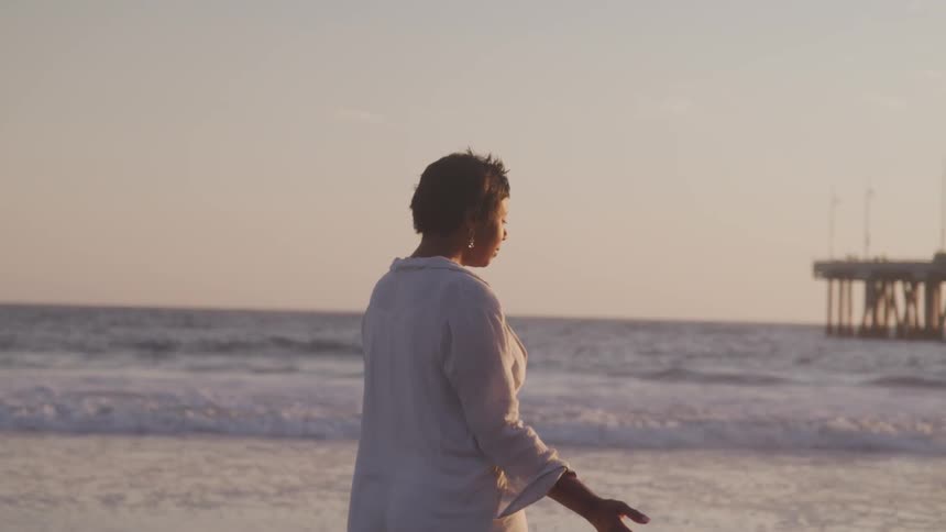 A portrait of middle aged woman standing near the beach